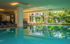 Innenpool mit Liegestühlen und großen Fenstern im Hotel Dorisol Estrelicia