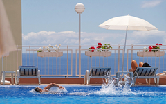 Pool mit Schwimmer und Liegen im Hotel Dorisol Estrelicia auf Madeira.