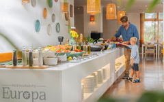 Ein Mann und ein Kind bedienen sich am Buffet in einem Restaurant.