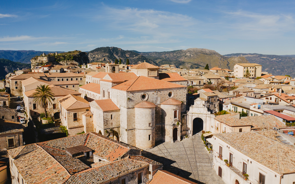 Historische Gebäude in Gerace, Kalabrien, Italien, umgeben von Hügeln.