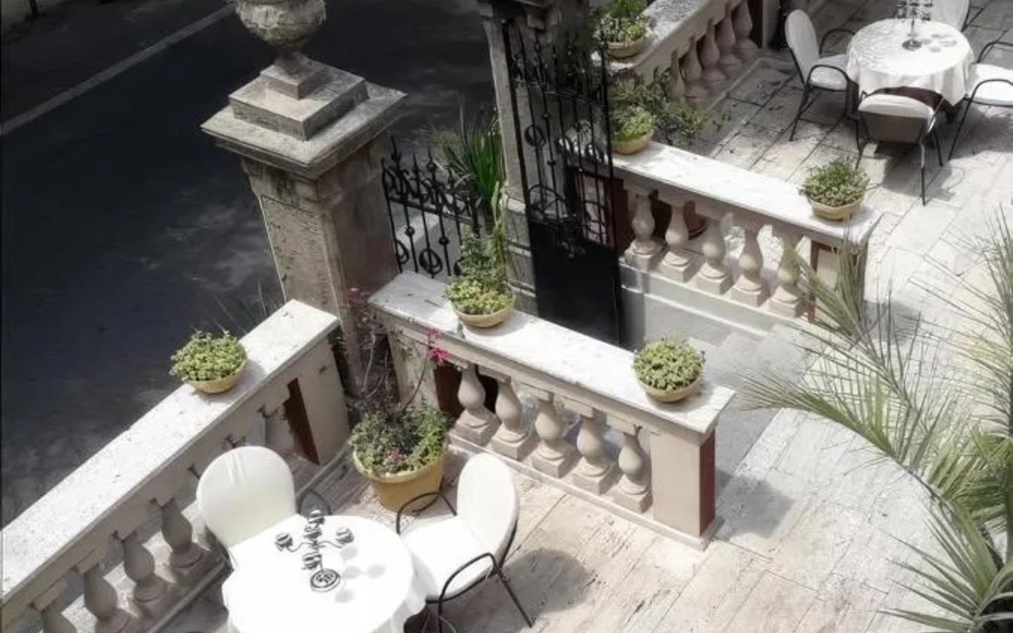 Terrasse des Hotel Villa Antica Tropea mit weißen Tischen und Stühlen.