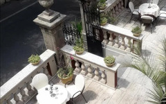 Terrasse des Hotel Villa Antica Tropea mit weißen Tischen und Stühlen.