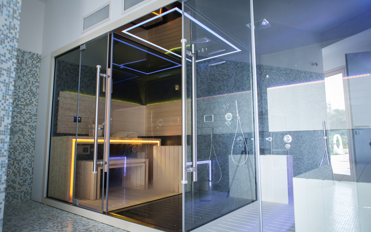Moderner Wellnessbereich mit Glaswänden und Beleuchtung im Luxushotel-Spa.