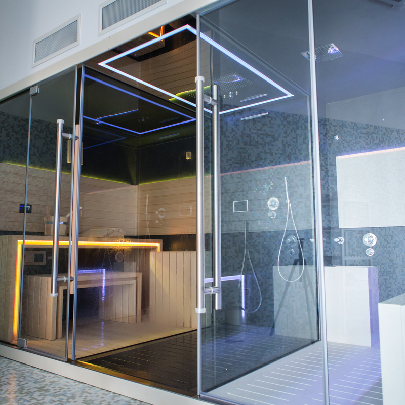 Moderner Wellnessbereich mit Glaswänden und Beleuchtung im Luxushotel-Spa.