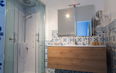 Modernes Badezimmer mit Glasduschkabine und Holzwaschtisch im Galia Luxury Resort.