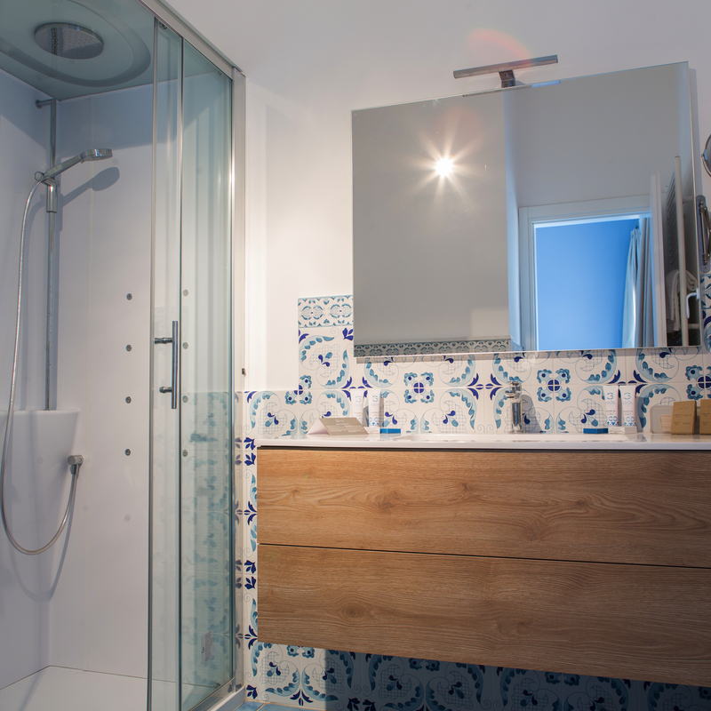 Modernes Badezimmer mit Glasduschkabine und Holzwaschtisch im Galia Luxury Resort.