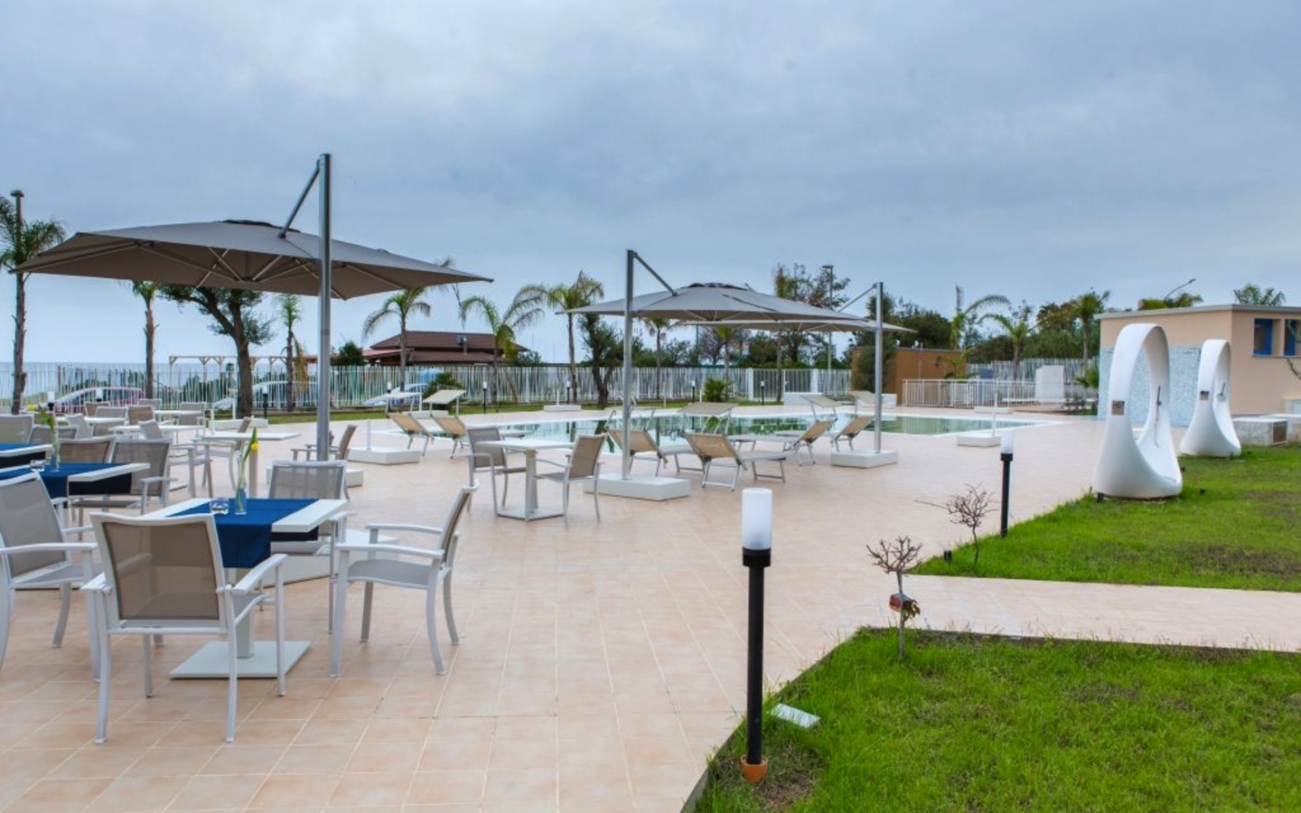 Terrasse mit Pool, Liegestühlen und Sitzbereich im Galia Luxury Resort, Kalabrien, Italien.