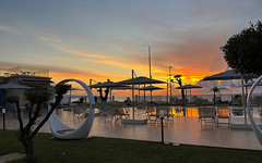 Poolbereich des Resorts Galia Luxury bei Sonnenuntergang, umgeben von modernen Liegen und Pflanzen.