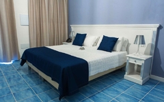 Hotelzimmer mit Doppelbett, blauer Bettdecke und Nachttischen im Galia Luxury Resort