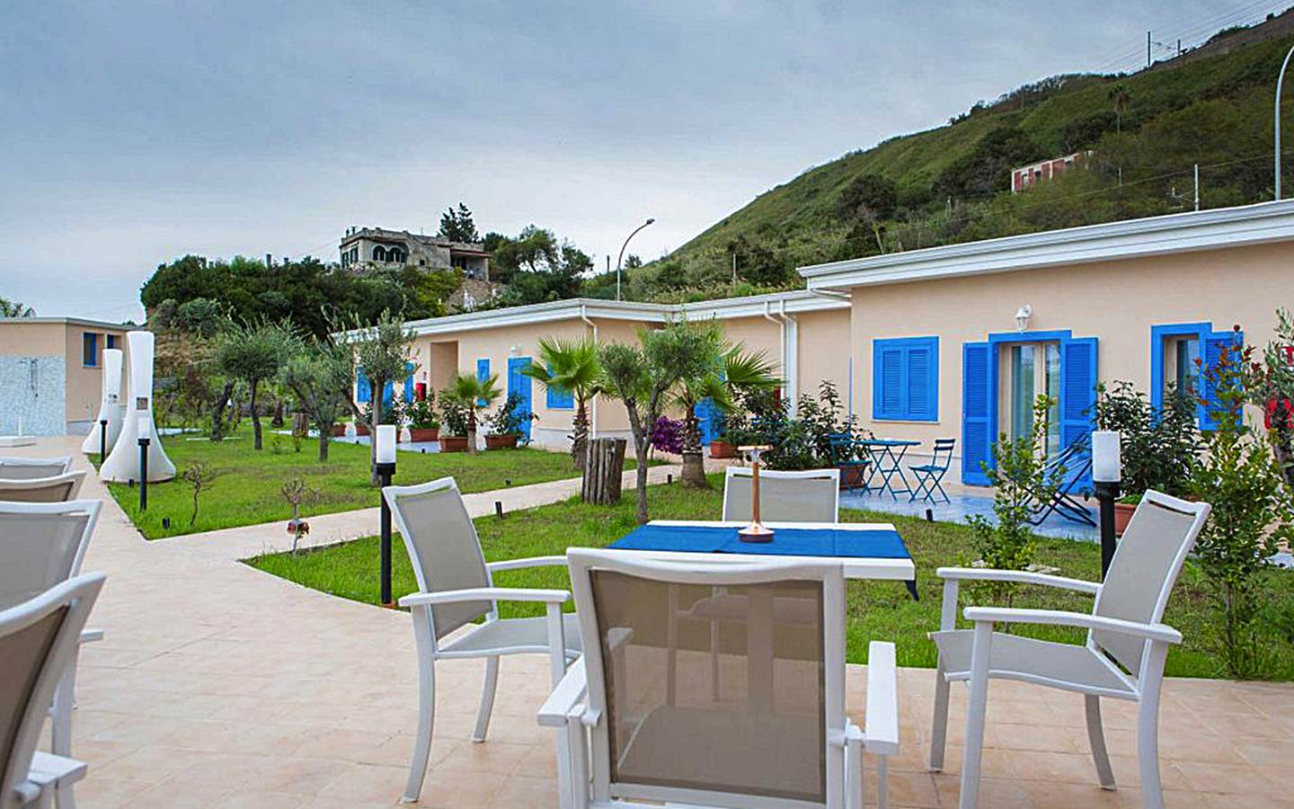 Gartenansicht des Galia Luxury Resorts mit Terrasse und umliegenden Hügeln.
