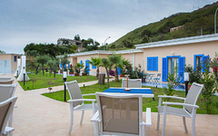 Gartenansicht des Galia Luxury Resorts mit Terrasse und umliegenden Hügeln.