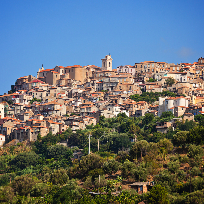 Malerisches Dorf auf einem Hügel mit zahlreichen Häusern und Vegetation.