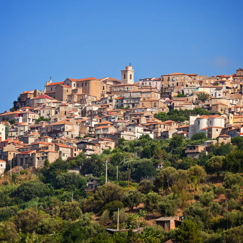 Malerisches Dorf auf einem Hügel mit zahlreichen Häusern und Vegetation.