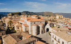 Historische Gebäude in Gerace, Kalabrien, Italien, umgeben von Hügeln.