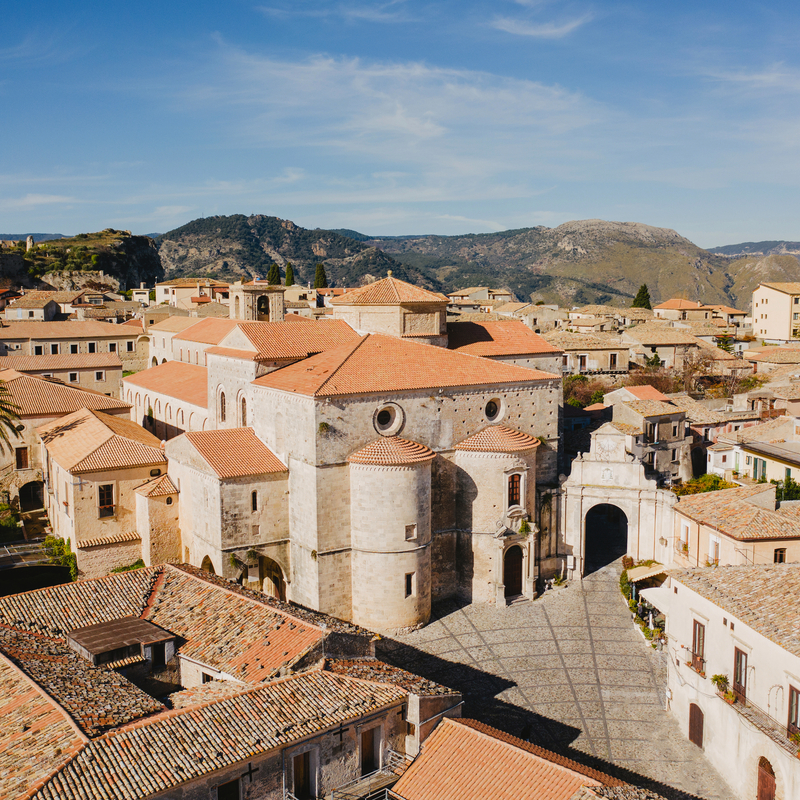 Historische Gebäude in Gerace, Kalabrien, Italien, umgeben von Hügeln.