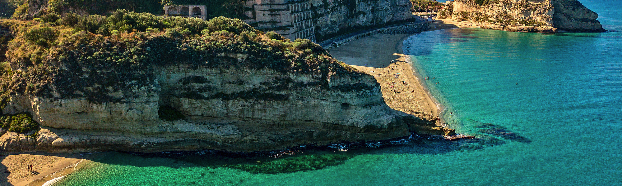 Küstenstadt Tropea in Kalabrien mit türkisfarbenem Meer und Strand.