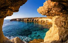 Küstenlandschaft bei Agia Napa auf Zypern mit azurblauem Meer und Felsformationen im Vordergrund.