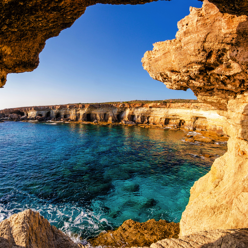 Küstenlandschaft bei Agia Napa auf Zypern mit azurblauem Meer und Felsformationen im Vordergrund.