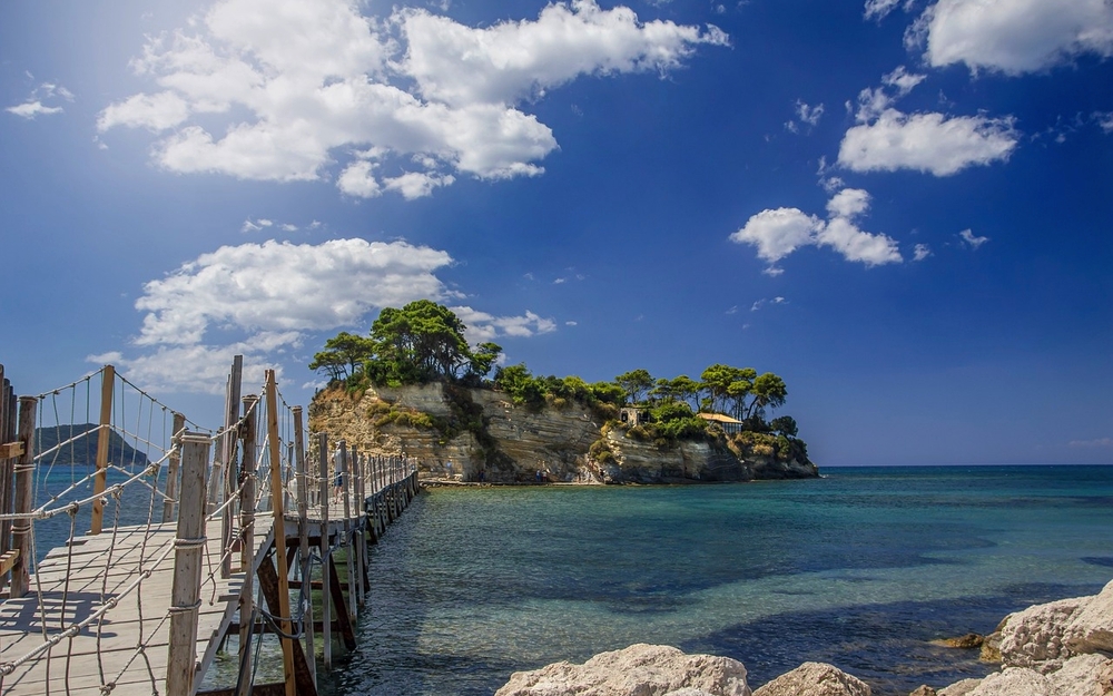 Steg zum Inselchen bei klarem Himmel und blauem Wasser.