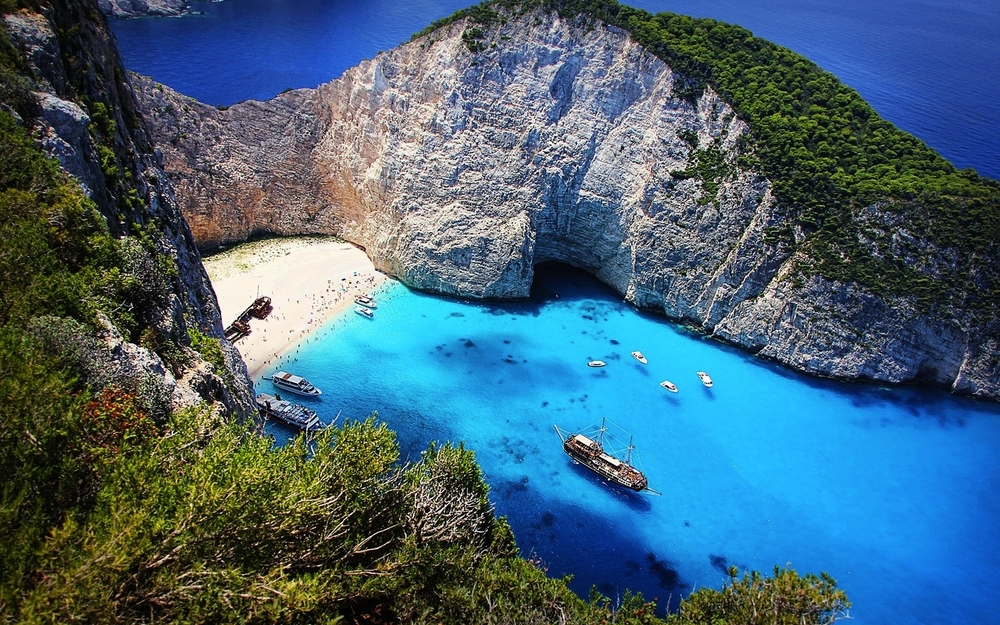 Küste mit Klippe, blauem Wasser und Booten auf Zakynthos, Griechenland.