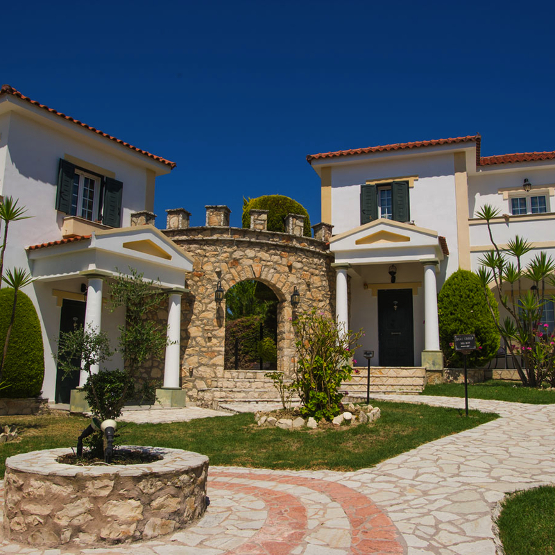 Heller Tag, Vorderansicht des Hotel Anagenessis Village, Gebäude und Garten.