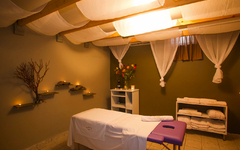Wellnessraum mit Massageliege und sanfter Beleuchtung.