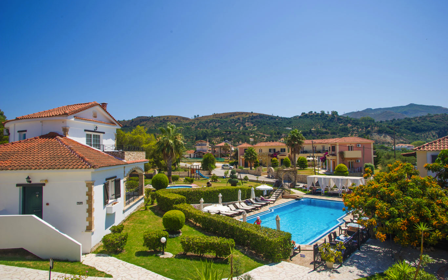 Außenansicht des Hotels Anagenessis Village mit Pool und Garten in Zakynthos, Griechenland.