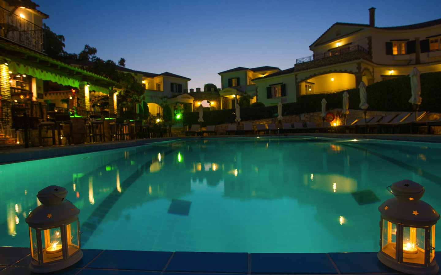 Hotelpool bei Abenddämmerung mit Lichtern und Laternen dekoriert