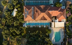 Luftaufnahme eines Hotels mit Pool und umgebener Vegetation.