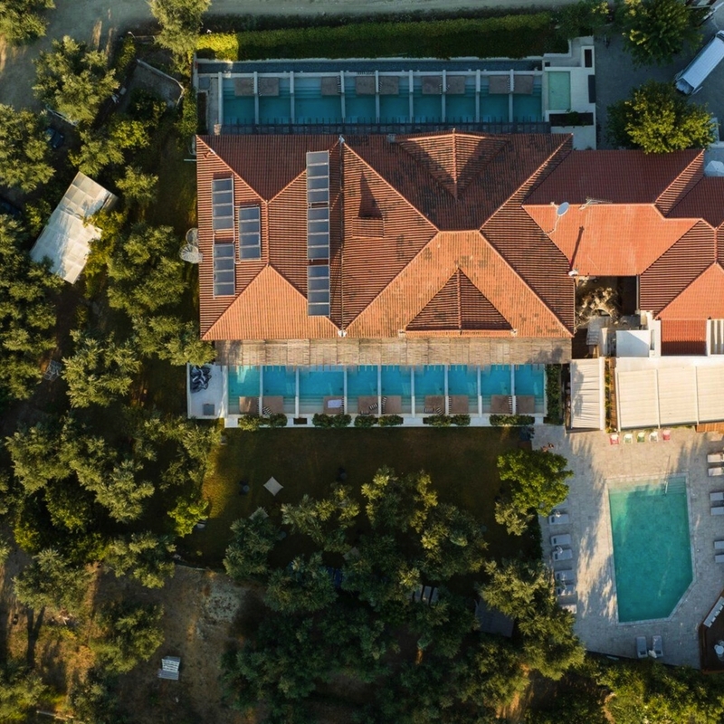 Luftaufnahme eines Hotels mit Pool und umgebener Vegetation.