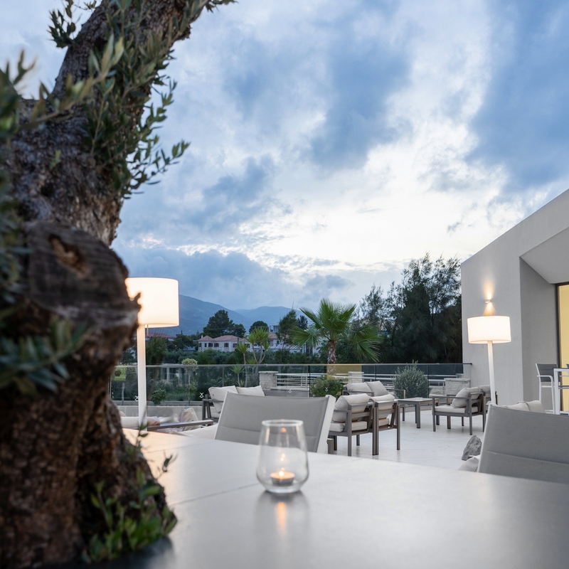 Moderne Außenterrasse mit Sitzgelegenheiten und umliegender Natur im Hotel Zante Sun.