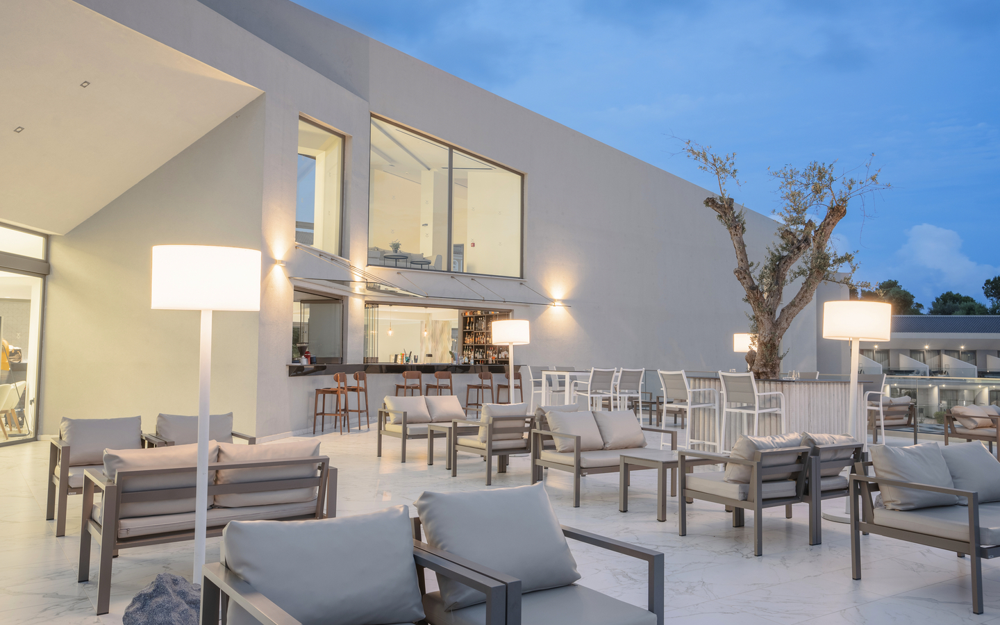 Moderne Hotelterrasse mit Sitzgelegenheiten und Bar im Freien.