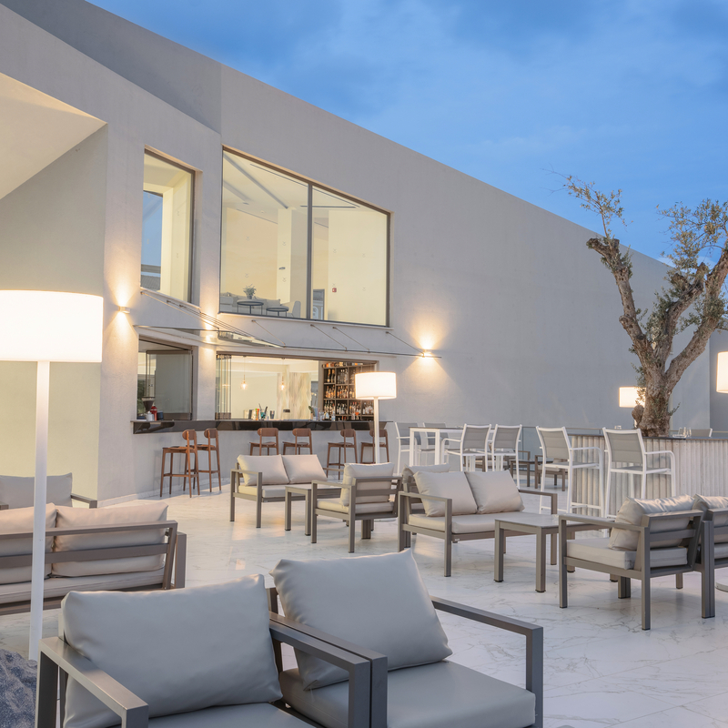 Moderne Hotelterrasse mit Sitzgelegenheiten und Bar im Freien.