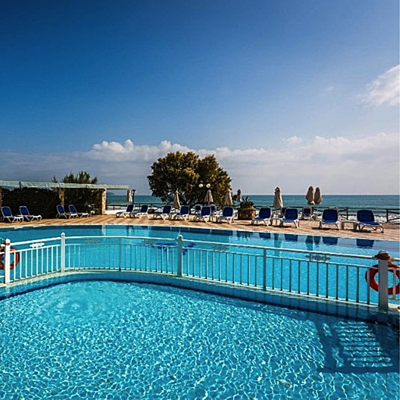 Außenpool mit Liegestühlen und Blick auf das Meer im Hotel Mediterranean Beach Resort