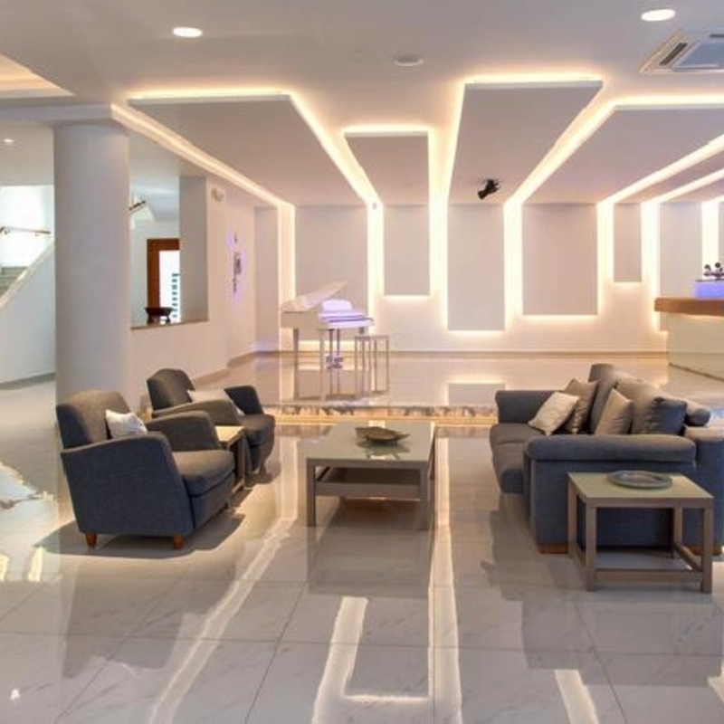 Helle Hotellobby mit Sitzbereich, Pflanzen und modernem Design.