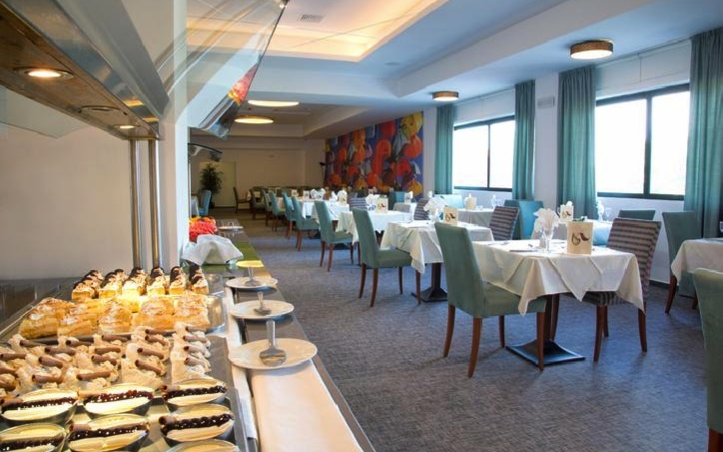 Ein Restaurant mit gedeckten Tischen und einem Buffet im Vordergrund.