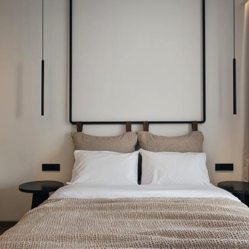 Doppelzimmer im Contessina Hotel, modern eingerichtet mit Doppelbett und Hängeleuchten.