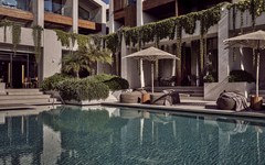 Hotelpool mit Liegestühlen, Sonnenschirmen und moderner Architektur im Hintergrund