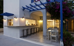 Außenbereich eines mediterranen Hotels mit weißen Wänden und blauen Akzenten.