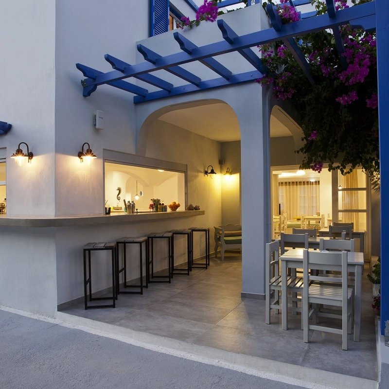 Außenbereich eines mediterranen Hotels mit weißen Wänden und blauen Akzenten.