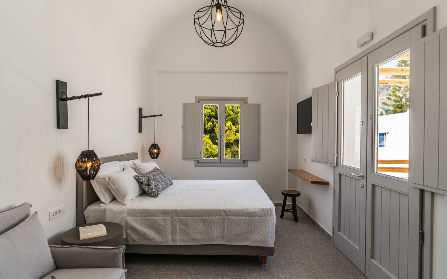 Modernes, helles Hotelzimmer mit Doppelbett und stilvoller Beleuchtung.