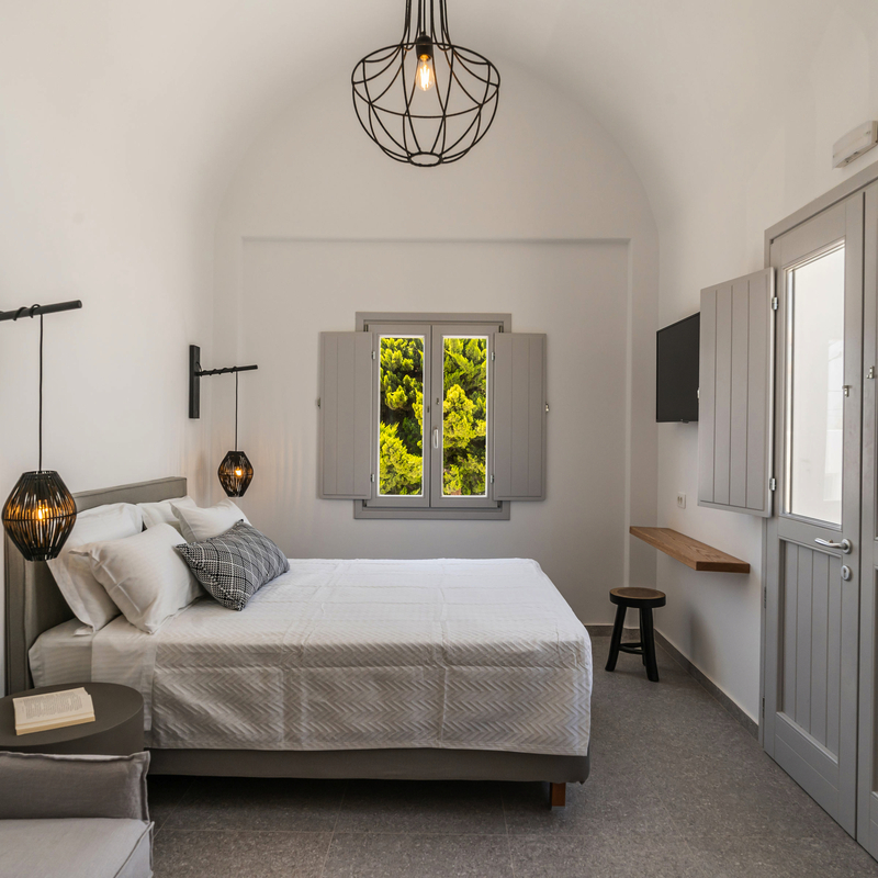 Modernes, helles Hotelzimmer mit Doppelbett und stilvoller Beleuchtung.