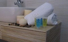 Badezimmer mit Waschbecken, Handtüchern und Badezimmerartikeln