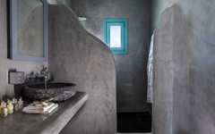 Badezimmer mit grauen Wänden, Steinwaschbecken und kleinem Fenster.
