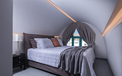 Luxuriöses Hotelzimmer mit gewölbter Decke und gemütlichem Bett in Santorin.