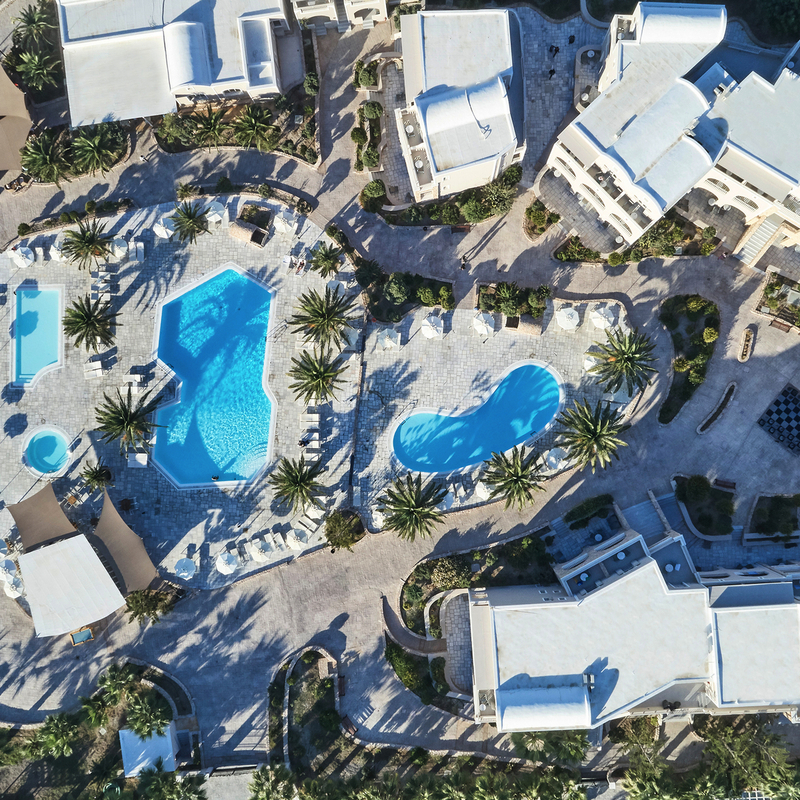 Luftaufnahme eines Hotelresorts mit Pools und Palmen, Santo Miramare, Santorin.