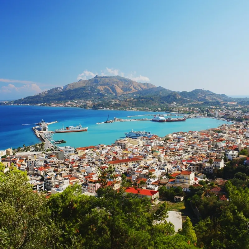 Panoramablick auf eine Küstenstadt mit Hafen und Bergen auf Zakynthos, Griechenland.