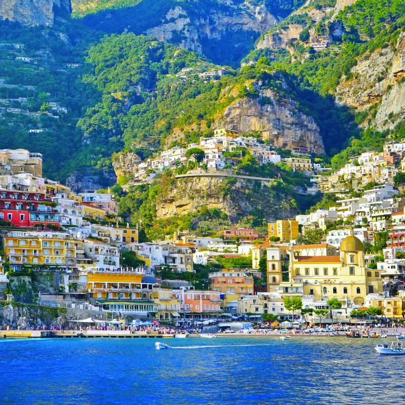 Bunte Häuser an einer steilen Küste oberhalb des Meeres.