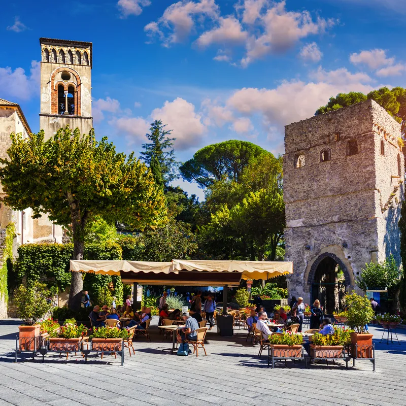 Historisches Stadtzentrum mit Café und alten Gebäuden bei Sonnenschein.