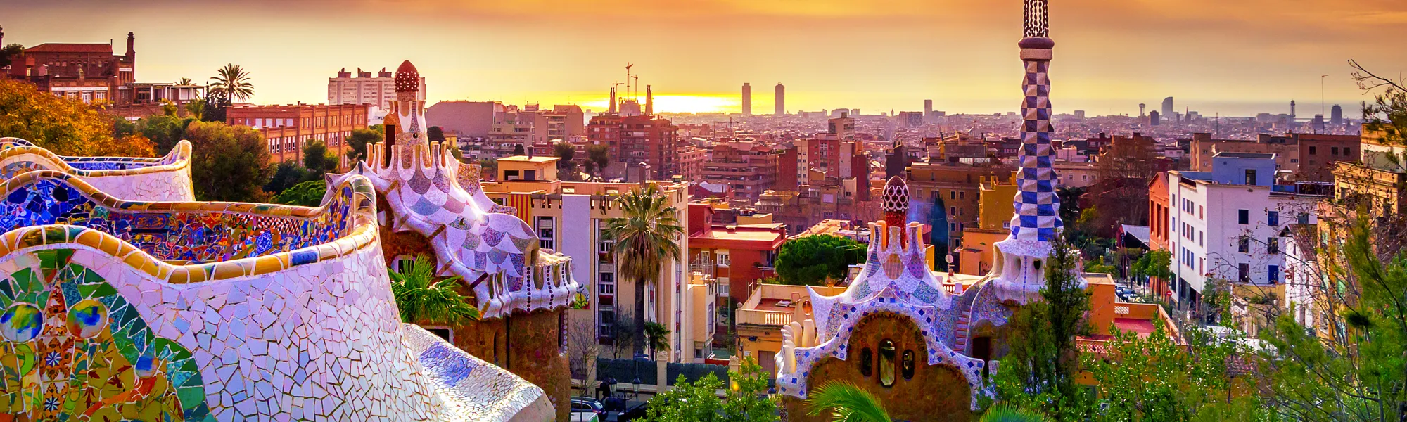 Sonnenuntergang über dem Park Güell in Barcelona mit Stadtblick.